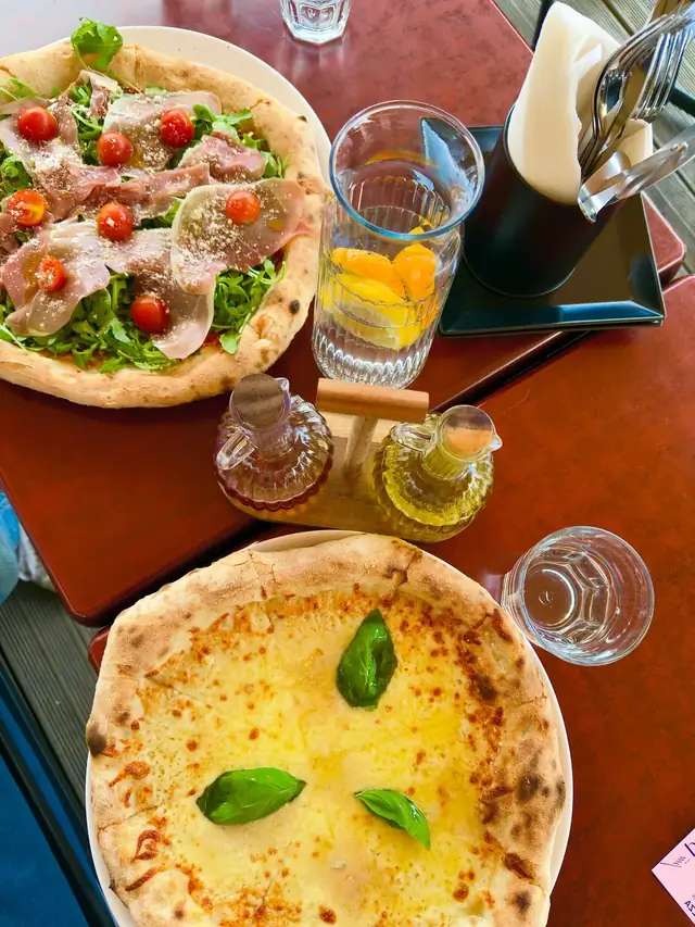 Dvě neapolské pizzy na stole v Pia